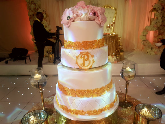 Four-tier gold and white wedding cake