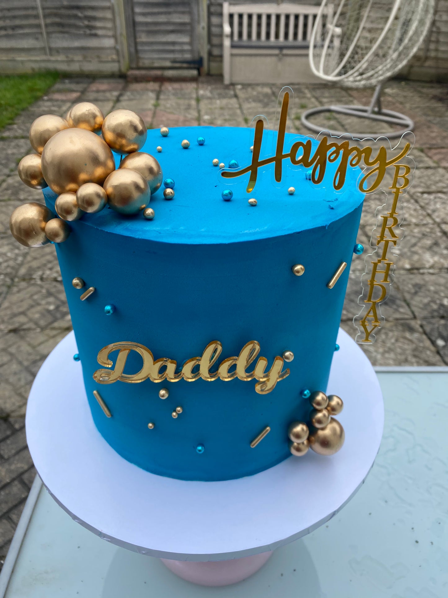 Deep blue cake with gold ball decorations