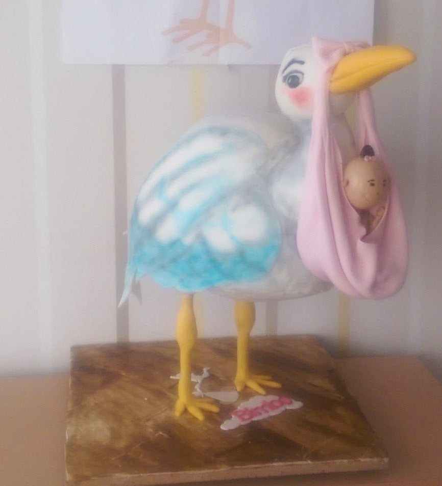 Stork carrying a baby cake